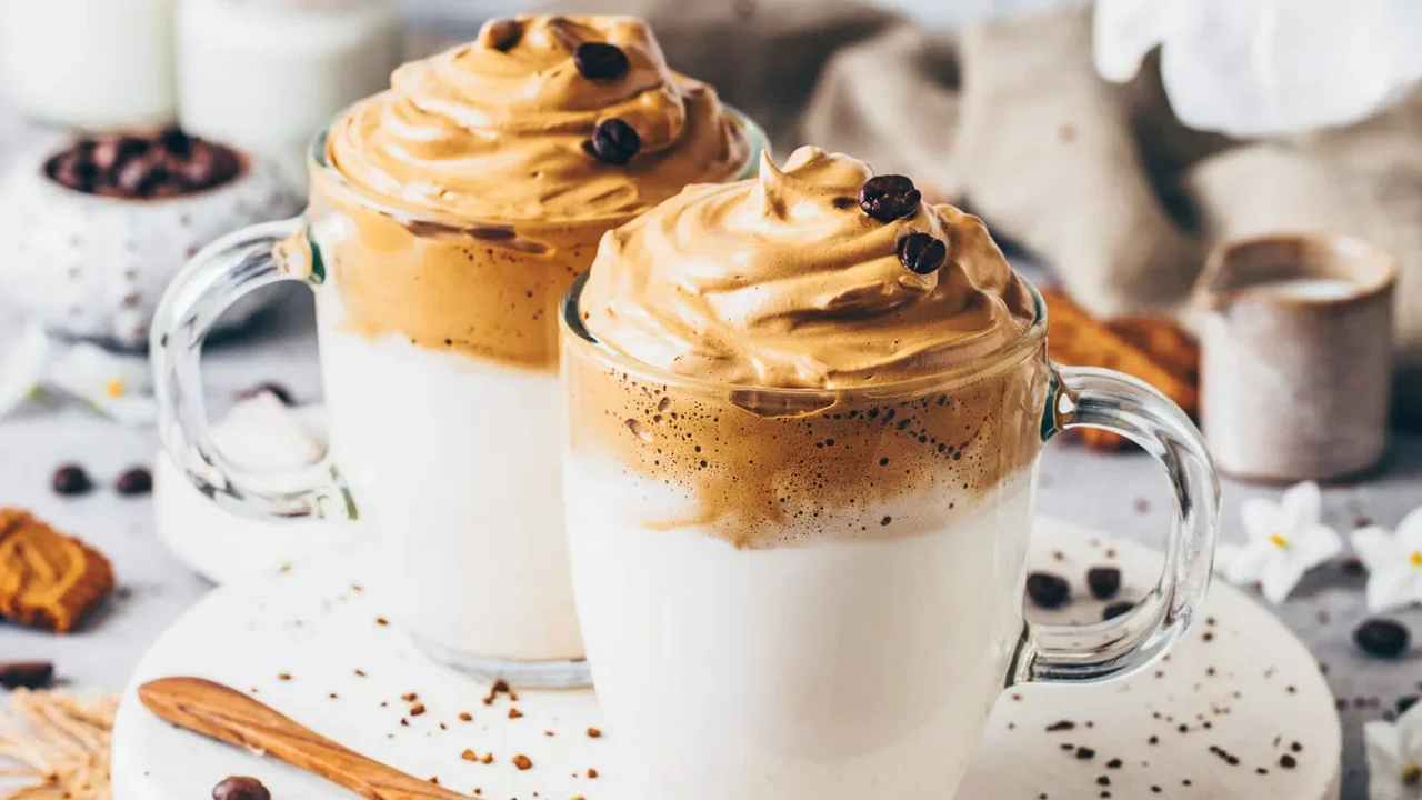 Two mint chocolate milkshakes with whipped cream and green sprinkles.